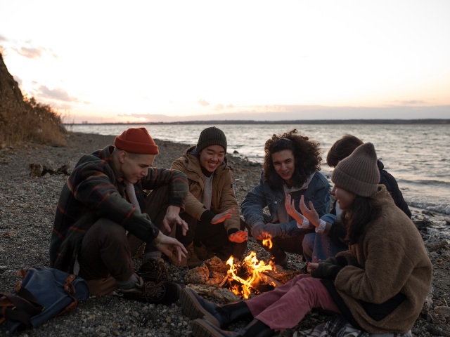 A group of friends sitting around a campfire. RV Lifestyle Experts