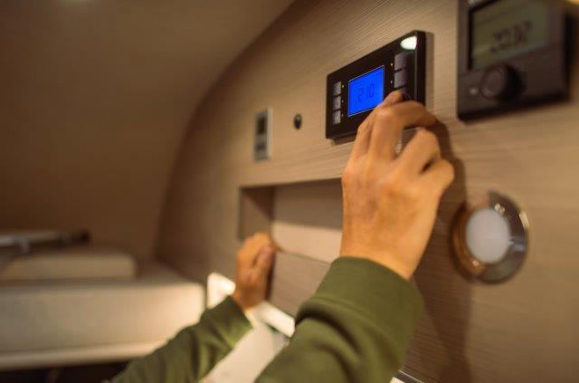 A person setting up a digital device with solar power for RV air conditioner. RV Lifestyle Experts