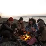 A group of friends sitting around a campfire. RV Lifestyle Experts
