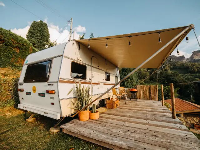 A white camper on a wooden deck in Avila Beach camping area. RV Lifestyle Experts