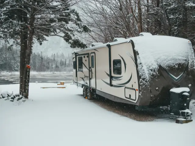 An rv parked in the snow near a river. Lake Perris Camping. RV Lifestyle Experts