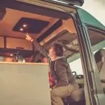 A Complete Guide to Solar Power for RV Air Conditioner A woman opens the door of a van. RV Lifestyle Experts