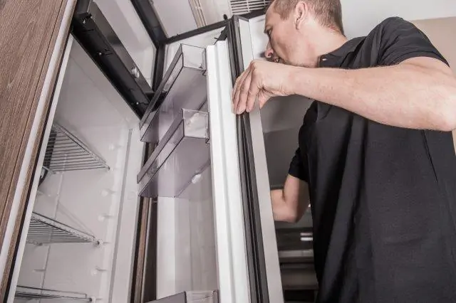 A man opening the door of an rv fridge for solar power. RV Lifestyle Experts