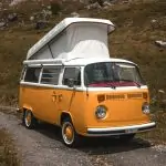 A yellow vw bus parked on a dirt road. RV Versus Camper. RV Lifestyle Experts