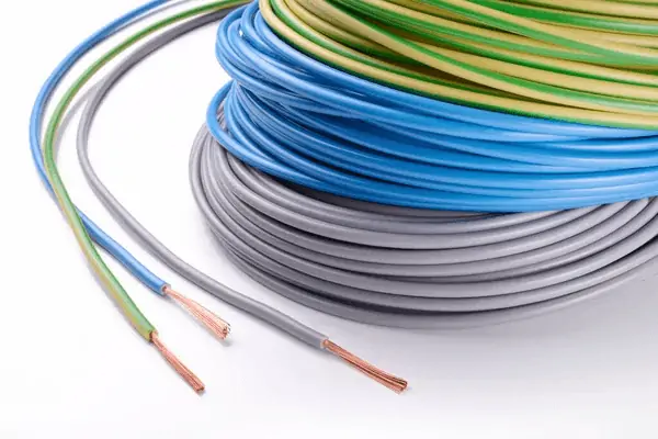 Coils of multicolored electrical wires with exposed copper ends, featuring blue, gray, and green colors, isolated on a white background. RV Lifestyle Experts